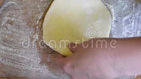 在木制桌子的背景上撒上面粉的面团视频的预览图