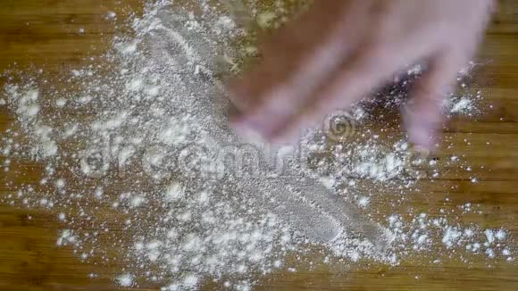 在木制桌子的背景上撒上面粉的面团视频的预览图