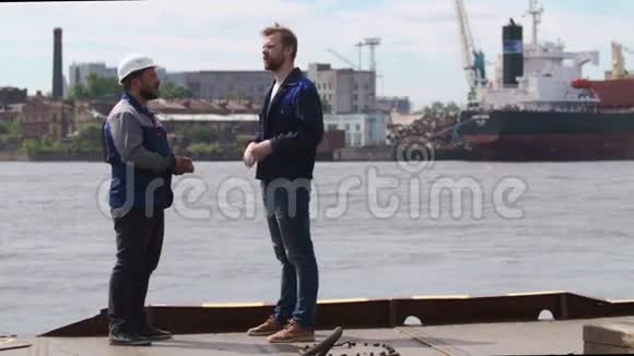 两名码头工人同事和同事在船运货运港握手视频的预览图