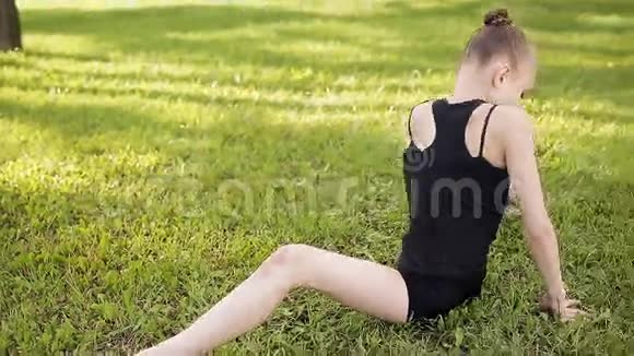 日落时分年轻女孩在城市公园做体操瑜伽和伸展运动视频的预览图