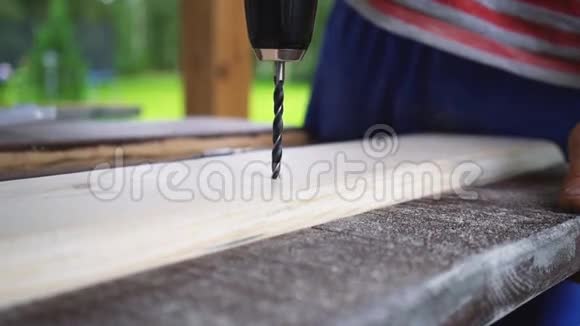 木工钻板上钻孔双手特写视频的预览图