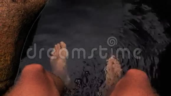 白种人在山涧形成的湖中洗脚视频的预览图