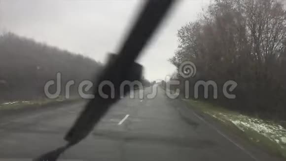 糟糕的户外柏油车驾驶雨秋寂寞的路慢动作视频视频的预览图