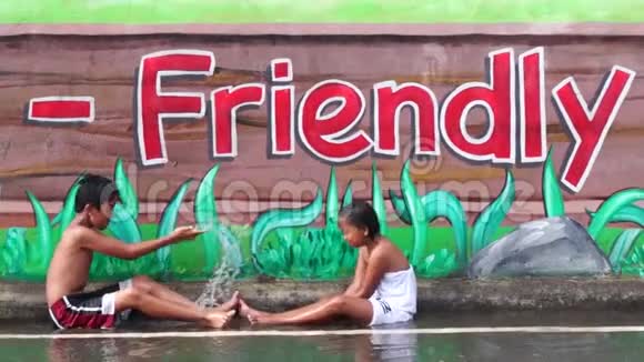 壁画混凝土学校墙是两个孩子享受雨浴的地方视频的预览图