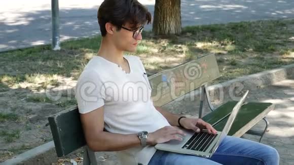 在公园电脑工作的帅哥视频的预览图