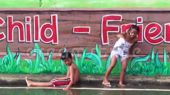 壁画混凝土学校墙是两个孩子享受雨浴的地方视频的预览图