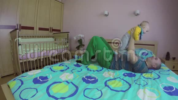 爸爸和宝宝一起在床上玩耍快乐的父母观念4K视频的预览图