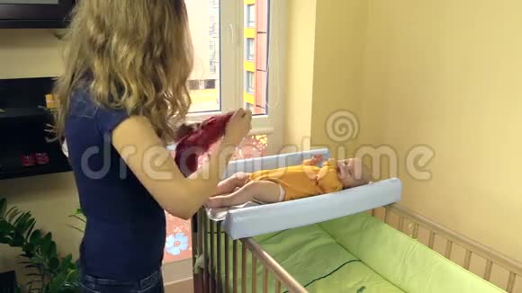 妈妈给宝宝穿粉色裤子孩子躺在更衣室里视频的预览图