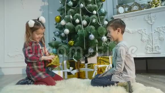 弟弟妹妹拆开礼物圣诞节和新年的概念视频的预览图