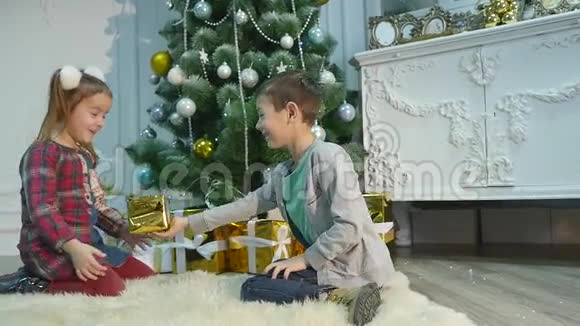 弟弟妹妹拆开礼物圣诞节和新年的概念视频的预览图