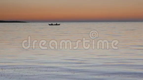平静的海面上有两个渔民在划船视频的预览图