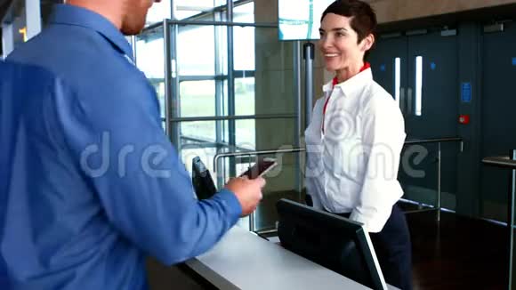 女机场工作人员在登记台检查通勤者护照视频的预览图