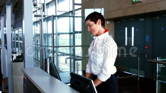 女机场工作人员在登记台检查通勤者护照视频的预览图