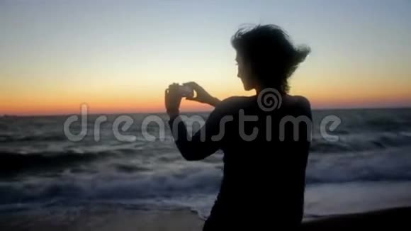 在海滩拍照的女人手持射击视频的预览图
