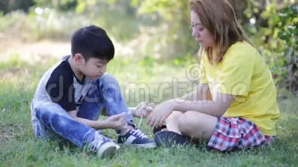 亚洲可爱的孩子和妈妈在公园系鞋带视频的预览图
