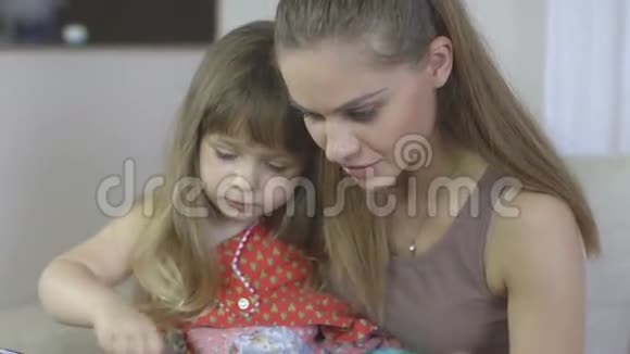 母亲和女儿在客厅看书的肖像视频的预览图