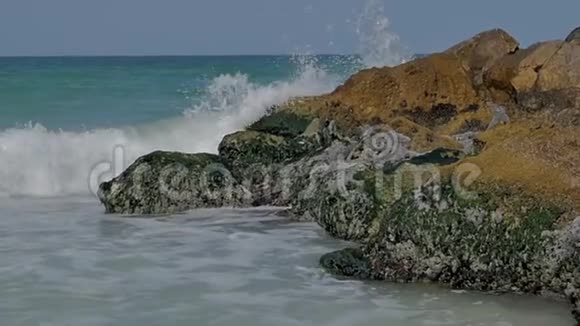 海边是沙质的海岸岩石上有浪花飞溅视频的预览图