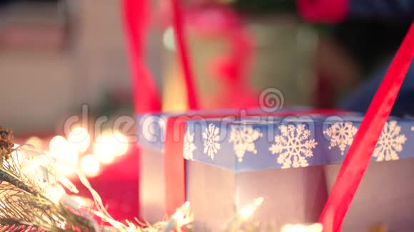 圣诞礼物包装圣诞前夜双手用红丝带系礼物视频的预览图