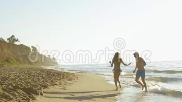 快乐的年轻夫妇在海边玩沙滩冲浪视频的预览图