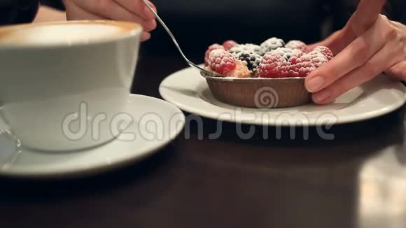 在咖啡馆里吃甜点和喝咖啡的女人特写视频的预览图