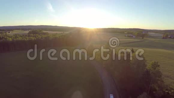 日落时分在乡间小路上飞过庄稼和汽车视频的预览图