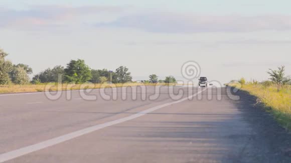 这辆车行驶在Pshenichnyh田野之间的乡村公路上日落时分在麦田的背景下视频的预览图