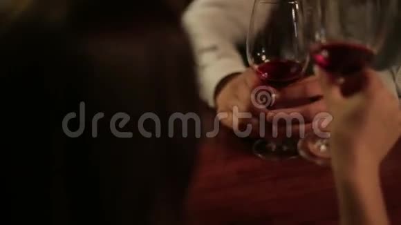 一对年轻的情侣紧握着一杯红酒餐厅提供浪漫晚餐视频的预览图