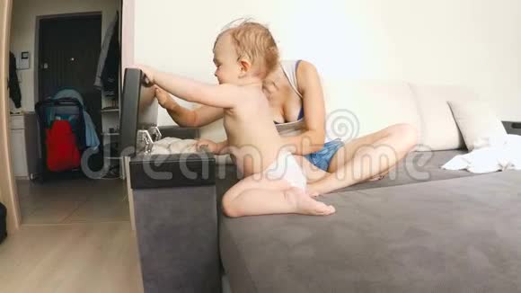 可爱的小男孩和妈妈在客厅沙发上玩耍视频的预览图