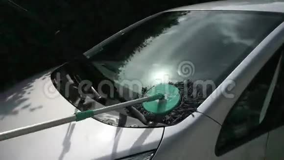 在用特殊刷子洗车时有人清洁挡风玻璃视频的预览图
