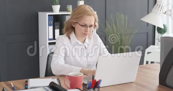 在笔记本电脑上工作的成熟女商人视频的预览图