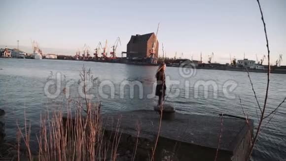 女人梳头在夕阳河港跳舞镜头上的阳光闪耀视频的预览图