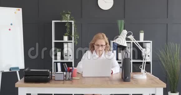 在笔记本电脑上工作的成熟女商人视频的预览图