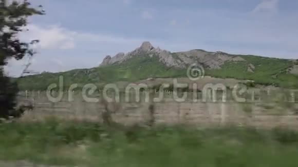 从一辆移动的汽车的窗户可以看到群山和葡萄园视频的预览图