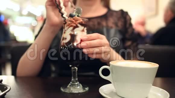 在咖啡馆里吃甜点和喝咖啡的女人特写视频的预览图
