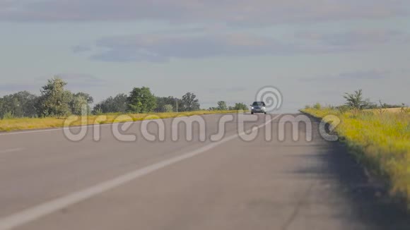 这辆车行驶在Pshenichnyh田野之间的乡村公路上日落时分的机器在麦田的背景下视频的预览图