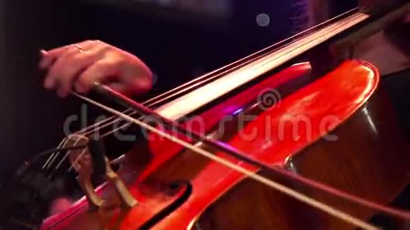 音乐家和许多同事一起在音乐会舞台上演奏大提琴视频的预览图