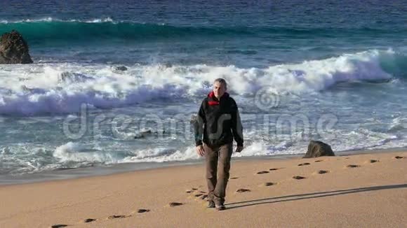 男子在海滩漫步背景是波浪视频的预览图