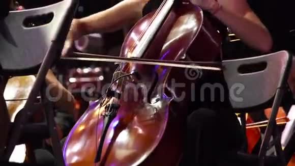 音乐会一个女音乐家在舞台上和很多同事演奏大提琴视频的预览图