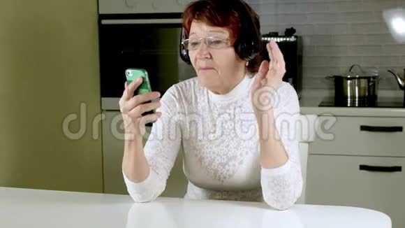 一位老年妇女从电话里用耳机听音乐积极地做手势跳舞视频的预览图