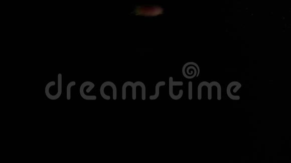 从黑色背景上拍摄的水中落下的桃子视频的预览图