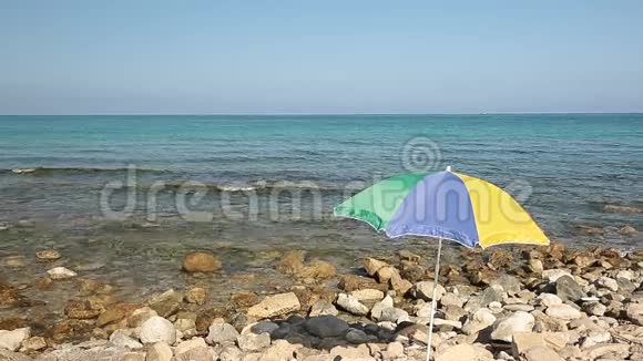 五颜六色的雨伞在岩石海滩上视频的预览图
