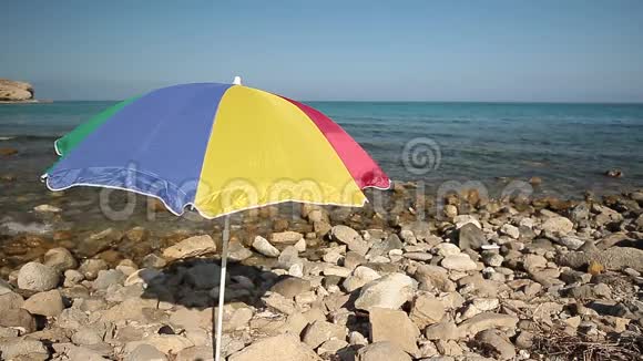五颜六色的雨伞在岩石海滩上视频的预览图