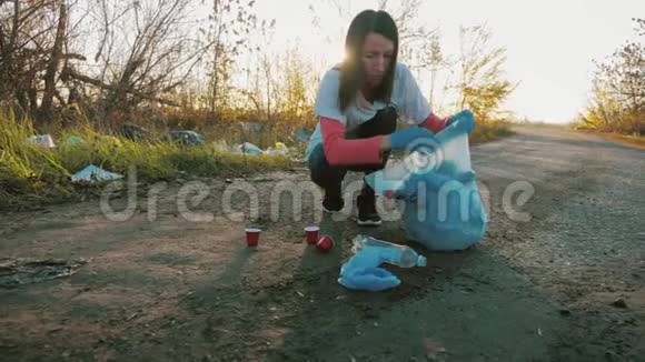 关心大自然志愿者女孩在垃圾袋里收集垃圾无垃圾星球概念自然清洁志愿者视频的预览图