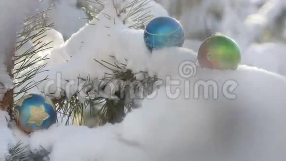 雪覆盖的冷杉树枝上的圣诞球视频的预览图