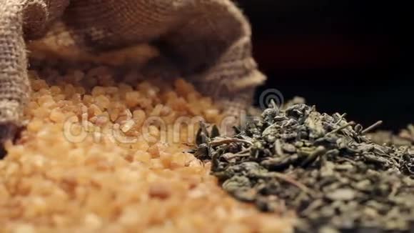 麻袋里的红糖和一堆干绿茶叶子旋转着视频的预览图