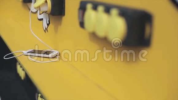 白色智能手机躺在街上的黄色桌子上充电夏日阳光明媚电话装置视频的预览图