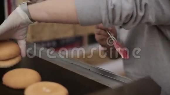 用蛋黄酱做汉堡用手套油包放在炉子上快餐露天活动视频的预览图