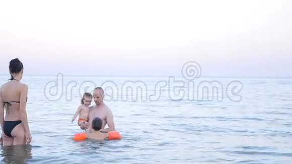 海上充气臂中有小女儿和小儿子的快乐父母视频的预览图