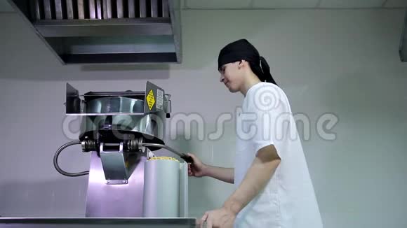 年轻迷人的白种人男性厨房工人戴着黑色头巾用干玉米种子填充爆米花机视频的预览图