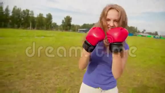 草地上拳击手套的女孩视频的预览图